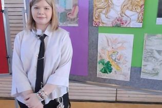 Uczennica Anna Bujnowska na tle prac